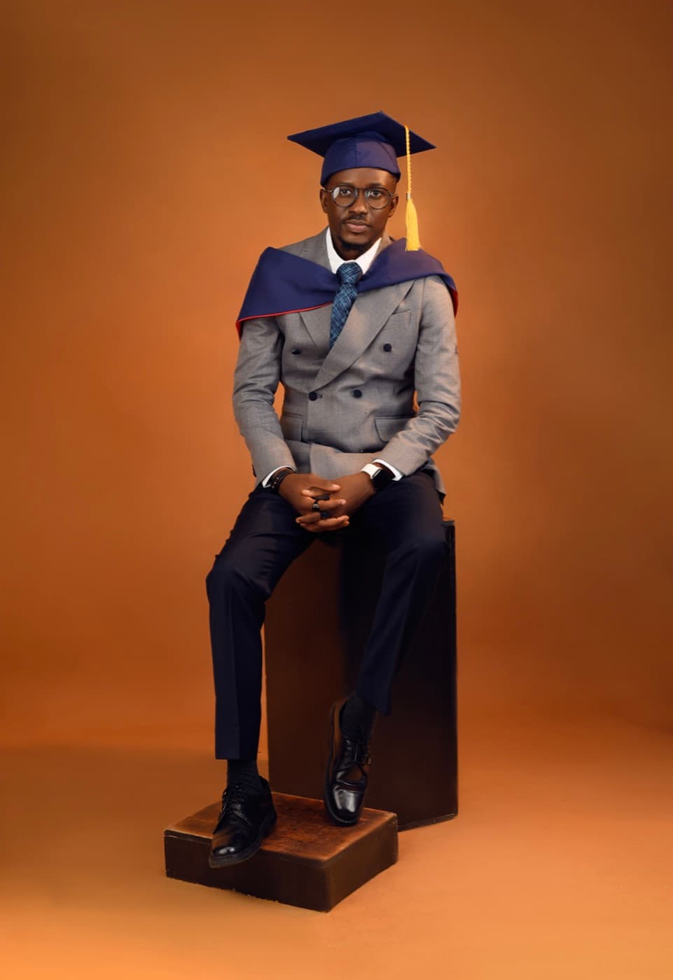 Blessing Ajala seated in cap and gown on graduation day